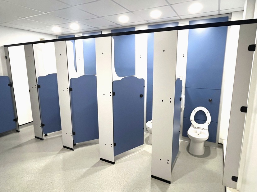 Rainbow school toilet cubicles with blue yellow and orange curved doors